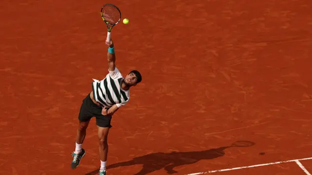 Carlos Alcaraz serves