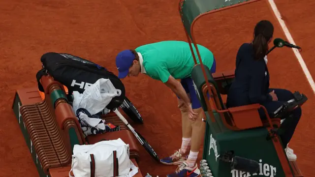 Jannik Sinner stands over his bench