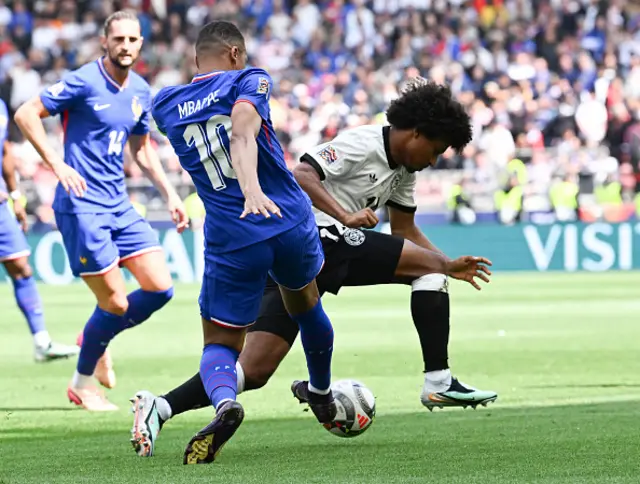 Karim Adeyemi (R) and France's forward Kylian Mbappe vie for the ball
