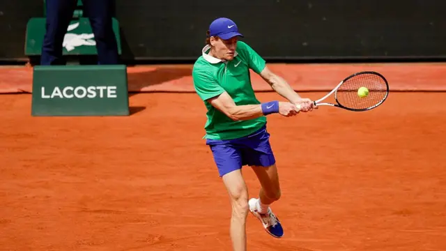 Jannik Sinner returns a backhand