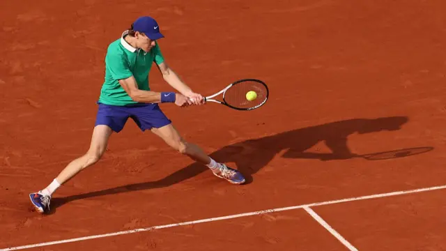 Jannik Sinner plays a backhand return