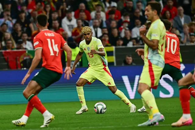 Lamine Yamal (C) plays the ball