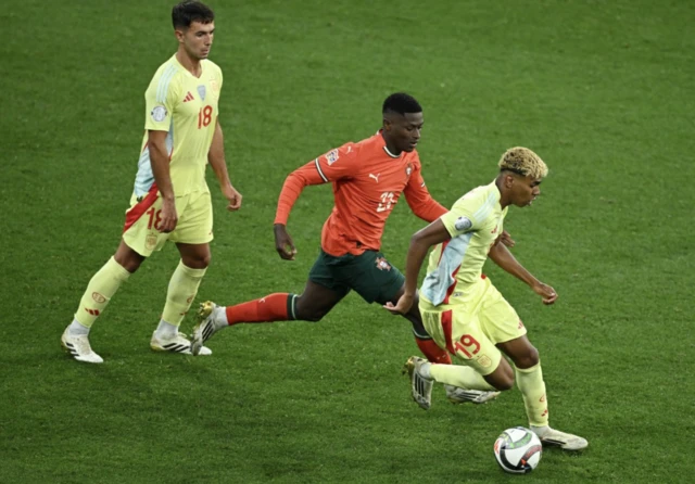 Spain's Lamine Yamal in action with Portugal's Nuno Mendes