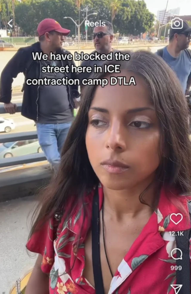 Mexican activist Kuali Linda Aleman, recording video with camera facing her. Text above her says We have blocked the street here in ICE contraction camp DTLA