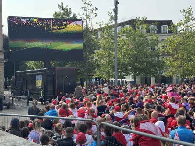 A crowd of Hull KR fans are watching a big screen