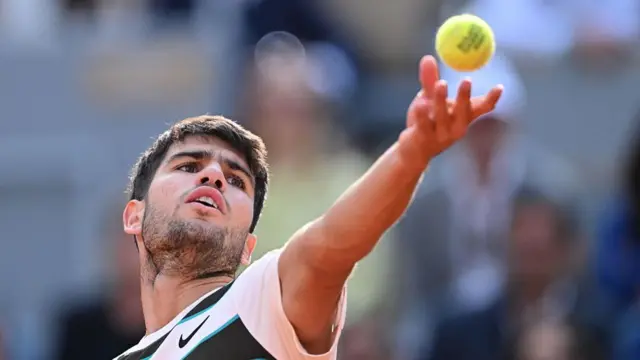 Carlos Alcaraz serves