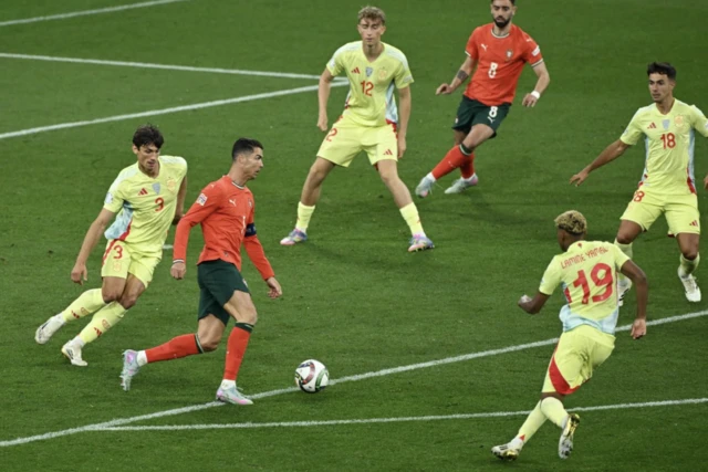 Portugal's Cristiano Ronaldo in action with Spain's Robin Le Normand and Lamine Yamal