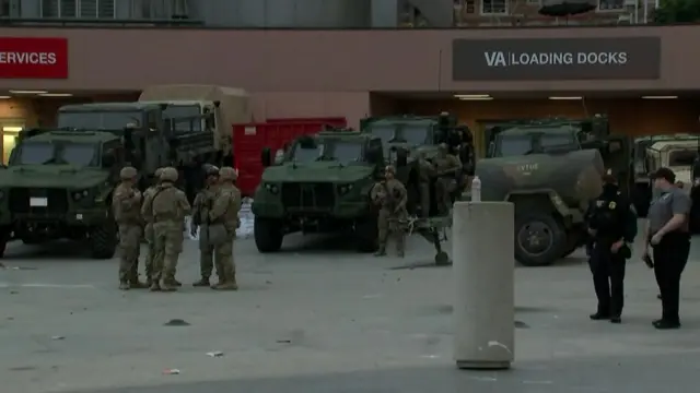 National Guard members stand by trucks