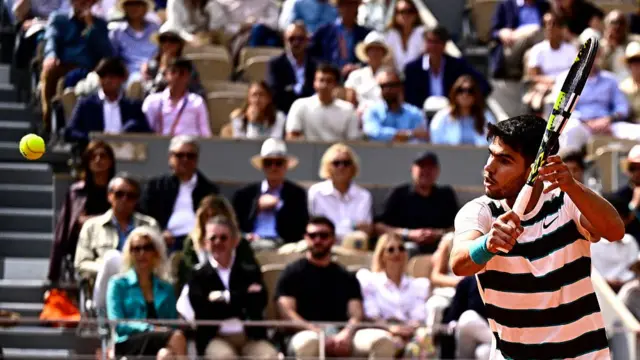Carlos Alcaraz plays a backhand return