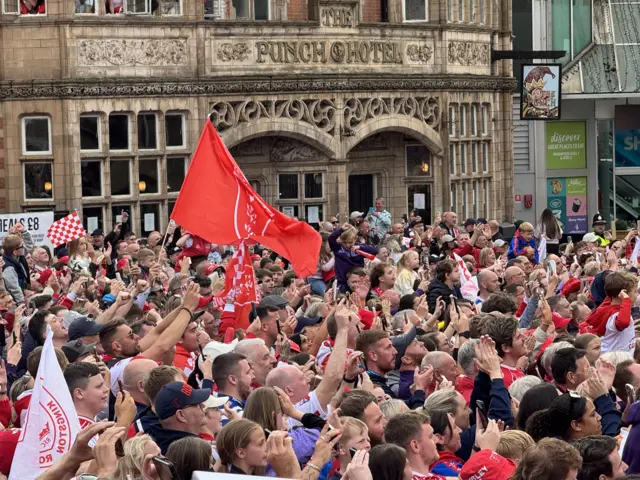 Fans hold phones to take photos of their winning team