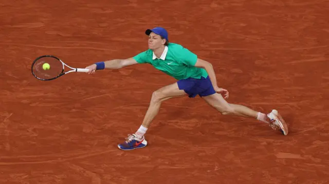 Jannik Sinner stretches for a forehand