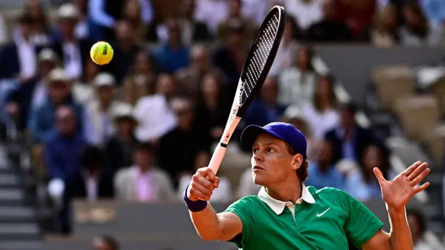 Jannik Sinner plays a backhand return