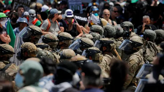 Demonstrators gather to protest against federal immigration sweeps, as members of the California National Guard stand outside the Edward R. Roybal federal building after their deployment by U.S. President Donald Trump