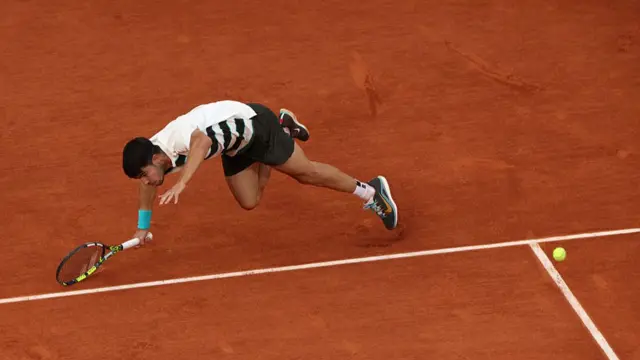 Carlos Alcaraz slips on the court