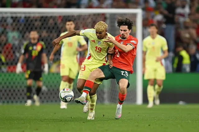 Lamine Yamal of Spain is challenged by Vitinha