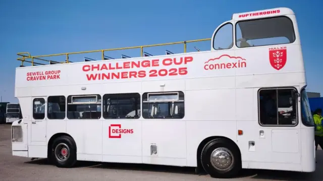 A white open-top bus with a red Hull Kingston Rovers logo. The words "Challenge Cup Winners 2025" are written on it in large text.