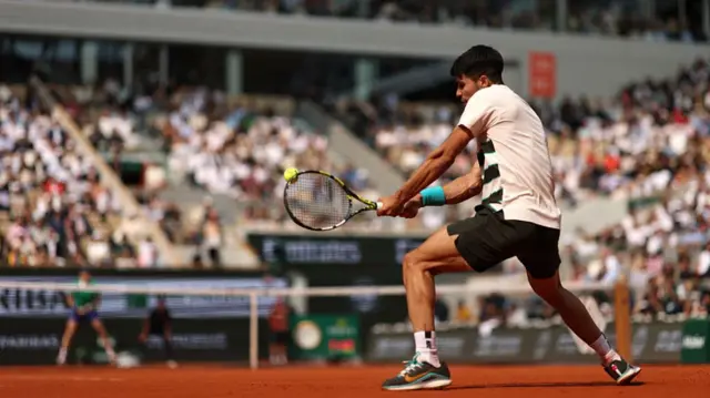 Carlos Alcaraz plays a backhand against Jannik Sinner