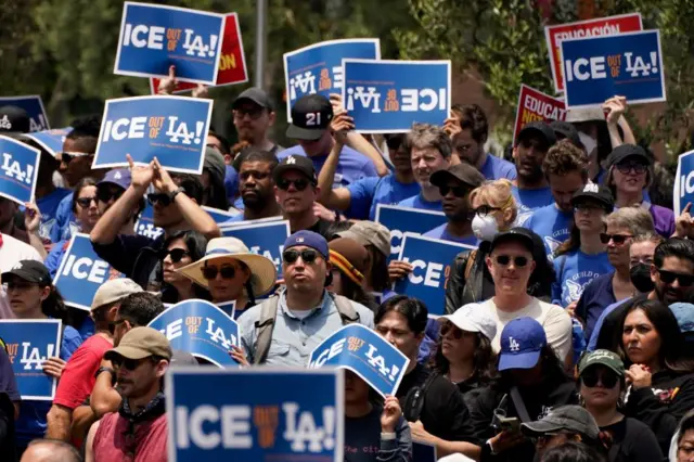 Dozens of people hold signs which say 'Ice out of LA!'
