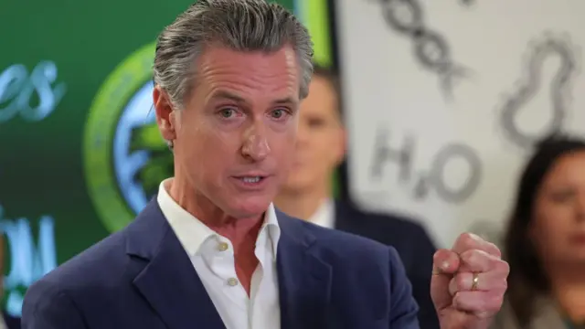 Gavin Newsom speaks, gesturing with a closed fist