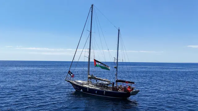A sailing yacht , with a Palestinian flag, in the water