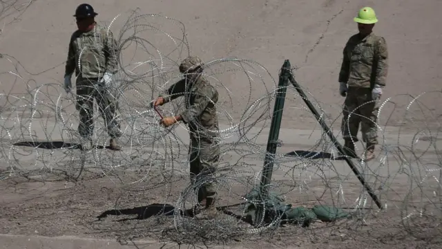 Members of the Texas National Guard install razor wire on the border with Mexico, in Juarez, Mexico, 07 May 2025.