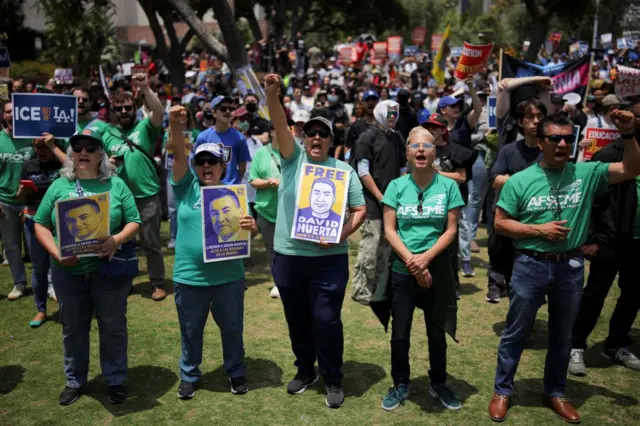 People hold posters which say 'Free David Huerta' at a rally