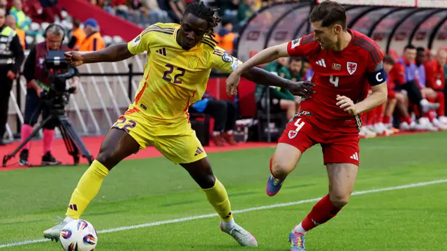Jeremy Doku of Belgium is challenged by Ben Davies of Wales
