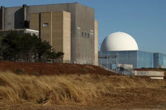 A view of Sizewell B on the Suffolk coastline. Various buildings can be seen including one with a large white dome on top of it.