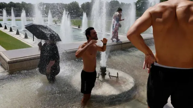 Tourists cool off in the Trocadero Fountain as an early summer heatwave hits Paris, France, July 1, 2025.