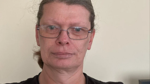 Stephanie, a 50 year old white woman, wearing glasses and a dark t shirt