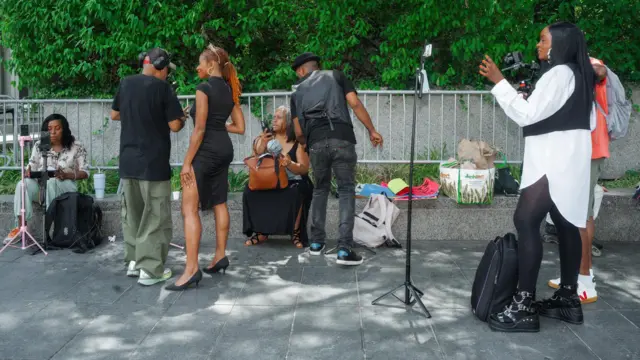 Twitch streamers and YouTubers work outside the federal courthouse during the jury deliberations