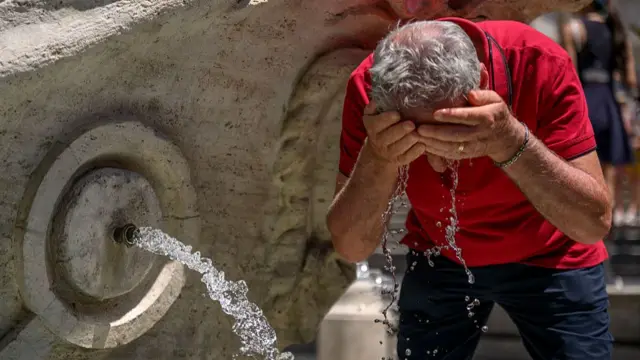 A man cools off in the Barcaccia fountain during an ongoing heatwave