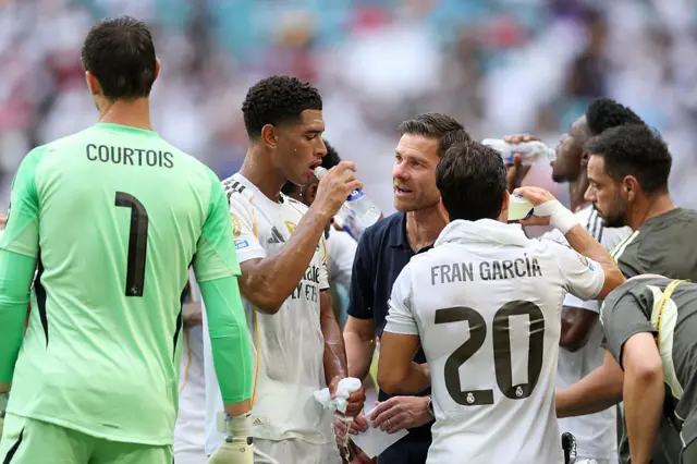 Real Madrid players speak to Xabi Alonso during the cooling break
