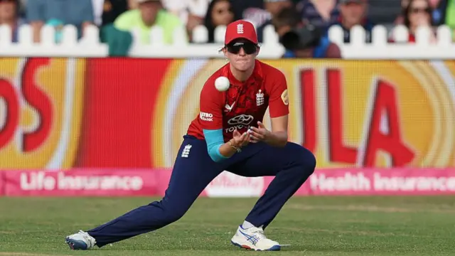 Lauren Filer of England takes the catch to dismiss Harmanpreet Kaur of India