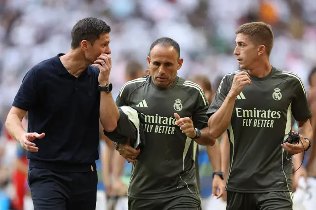 Xabi Alonso in discussion with his coaches