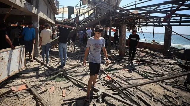 A man walks amid rubble at a seaside cafe in Gaza