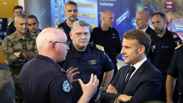 Macron listens to a military officer.