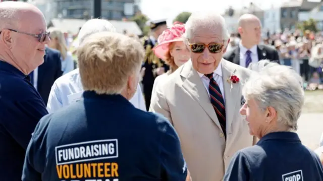 King Charles shakes hands with RNLI volunteers