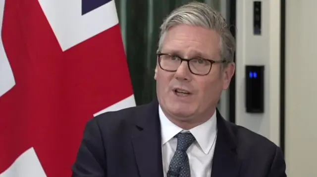 Keir Starmer at a news conference in front of the British flag