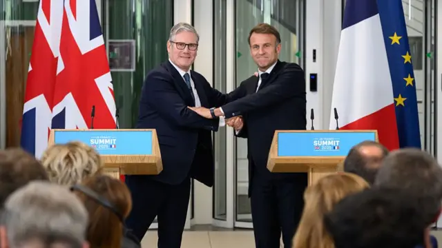Keir Starmer and Emmanuel Macron shake hands across podiums