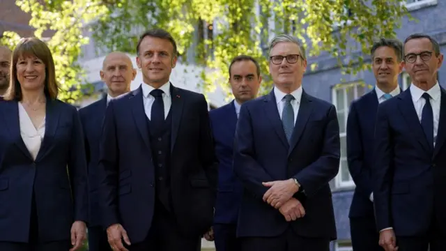 Britain's Prime Minister Keir Starmer and French President Emmanuel Macron stand beside Rachel Reeves, Chancellor of the Exchequer, as they pose for a group picture during the UK-France summit at 10 Downing Street in London.