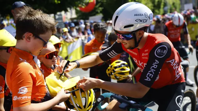 Kevin Vauquelin signs an autograph before stage six of the 2025 Tour de France
