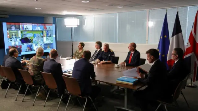 World leaders including Starmer, Marcron and Zelensky, Meloni on the screen are sat around a table discussing plans foe a peacekeeping force.