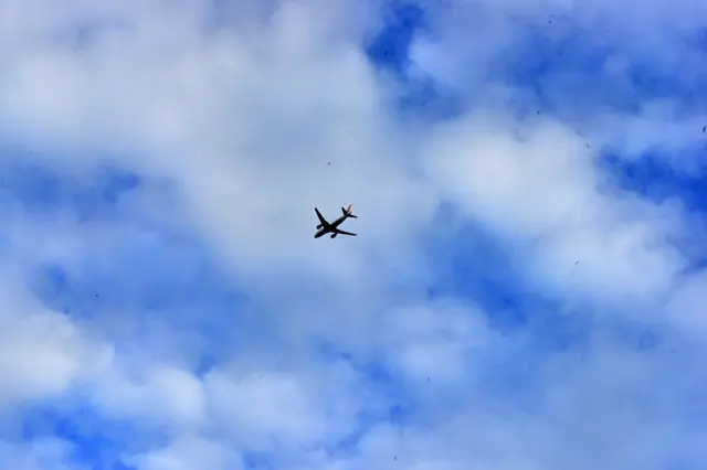 An aircraft flies in the sky as clouds loom over in Siliguri, India, on May 26, 2025. (Photo by Diptendu Dutta/NurPhoto via Getty Images)