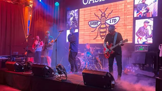 A close up of the tribute band playing on stage, attempting to look like Oasis.