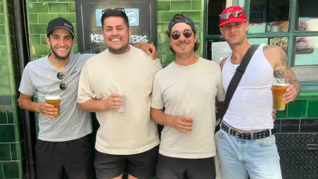 Paul, Brandon, Jordan, and Michael all standing together smiling. They are all holding a drink.