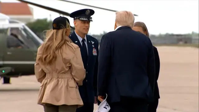 Donald Trump and Melania Trump speak to officials upon arrival