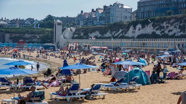 Very busy Viking Bay on a sunny and very hot day in Broadstairs. Broadstairs is a coastal town in the Isle of Thanet, Kent, England. It is located between Margate and Ramsgate. Broadstairs is a very famous seaside resort which attracts tourists all year around.