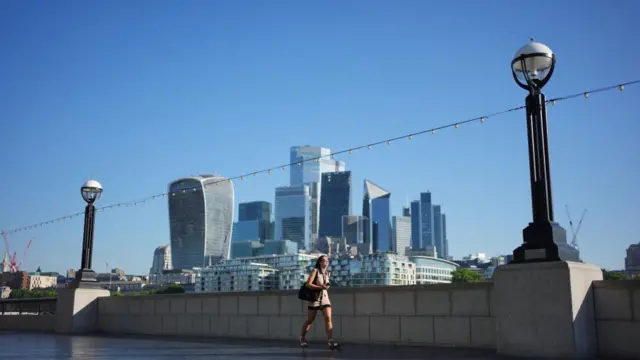 A person walks along The Queen's Walk near Tower Bridge in London.
