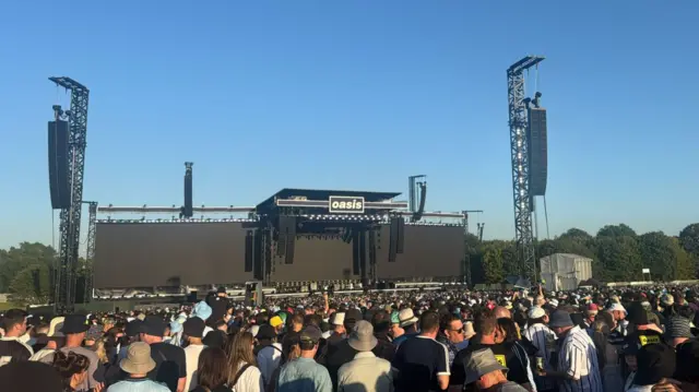 A wide shot of the empty stage with a huge crowd in front.